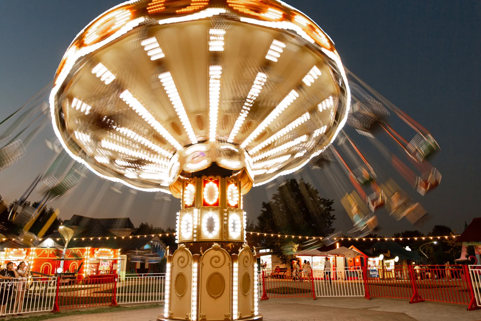 Photo Booth Software for Family Entertainment Centers 5 Illuminated swing carousel ride spinning at dusk at an amusement park