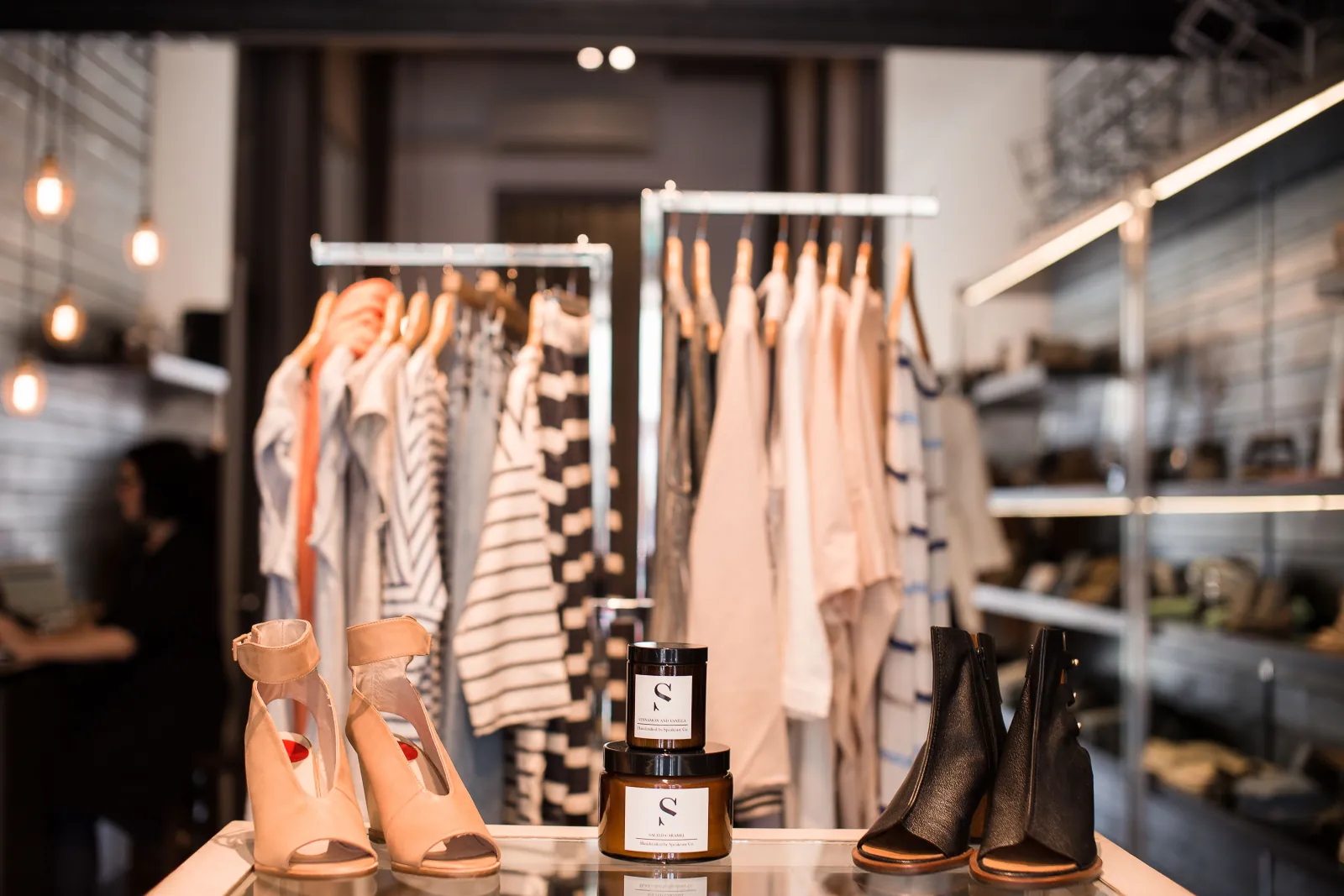 Photo Booth Software for Brand Stores and Pop-Ups 2 Curated boutique display table with shoes and candles in front of hanging garments