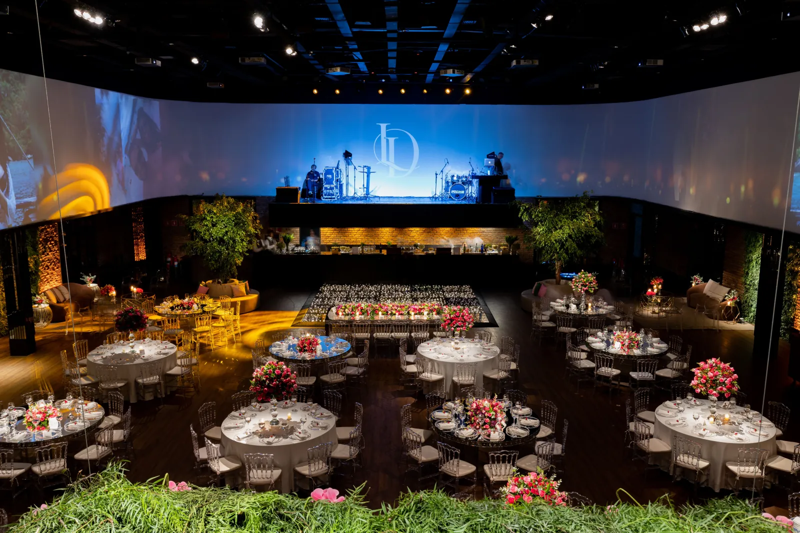 Photo Booth Software for Corporate Events 2 Round banquet tables facing a wide stage screen at a corporate event in a ballroom