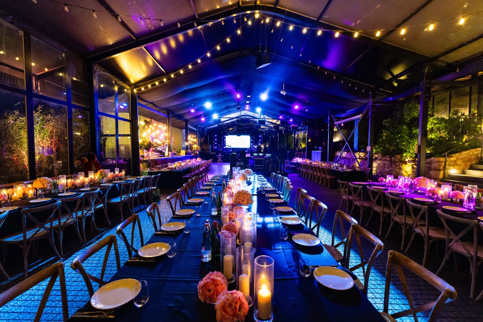 Photo Booth Software for Corporate Events 1 Long banquet tables set under string lights and blue uplighting at a corporate gala dinner