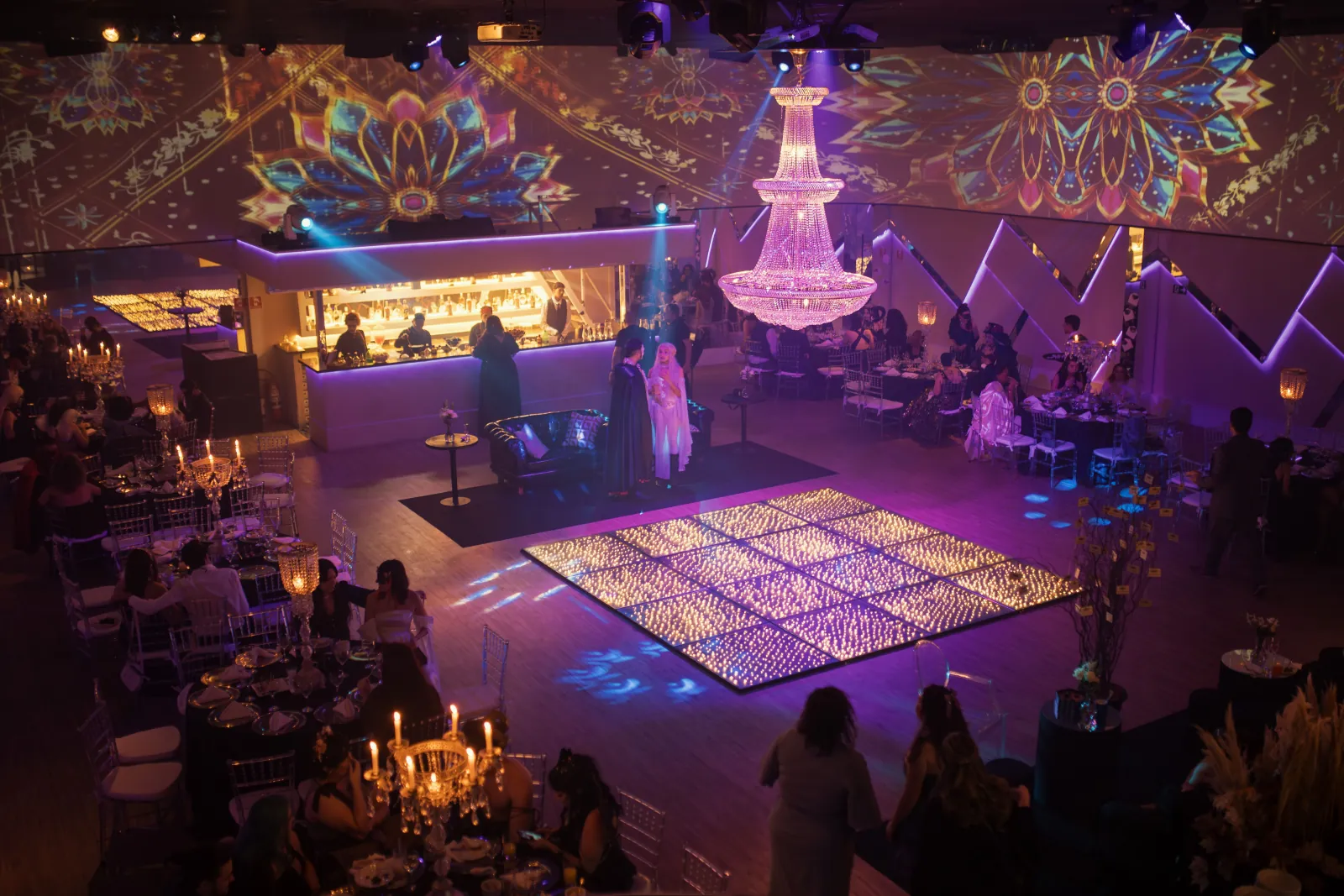Illuminated LED dance floor beneath a crystal chandelier at a wedding ballroom venue